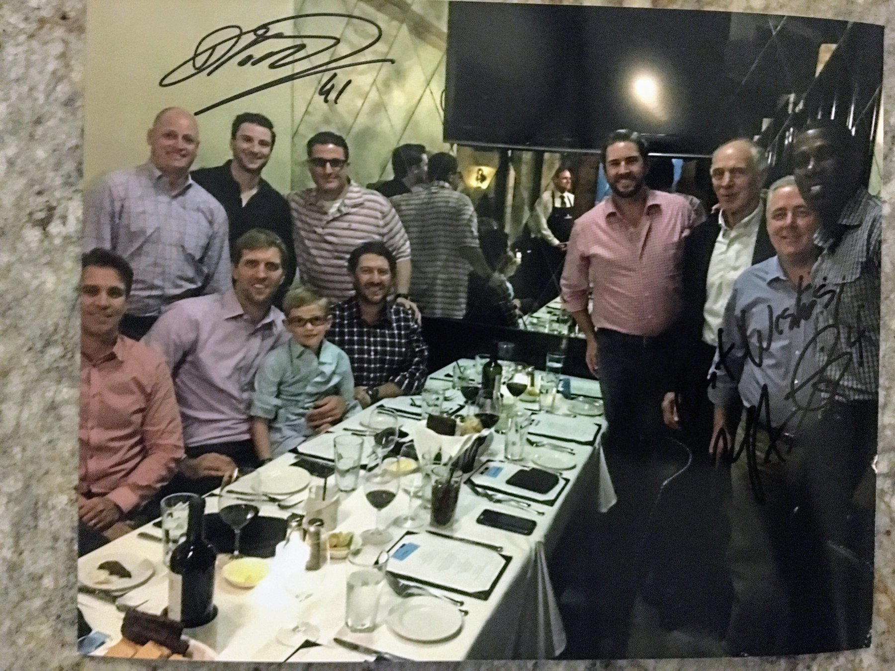 Andrew Hillman and Ashton Hillman at a signed dinner with Dirk Nowitzki #41. Ashton Hillman seated at the table; Andrew Hillman standing in the group.