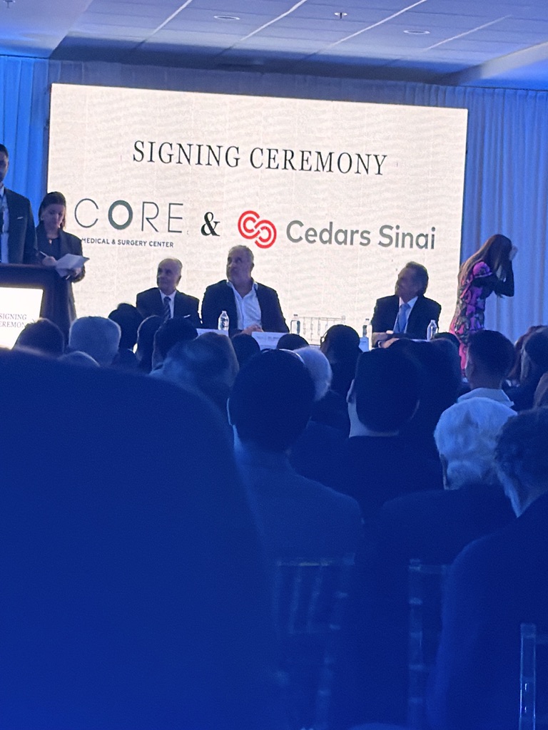 Signing ceremony of CORE hospital with Cedars Sinai. Backdrop text: SIGNING CEREMONY, CORE Medical & Surgery Center & Cedars Sinai.