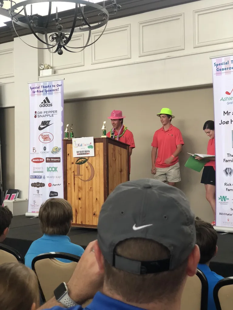 Andrew Hillman Dallas. Mighty Fore huddle at KidSwing, hats showing Mighty Fore and KidSwing