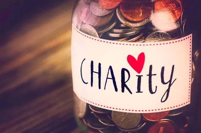 Coin jar labeled Charity with a red heart
